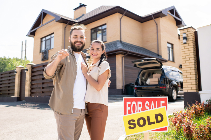 Happy Evansville couple with keys and SOLD sign in front of their home — the outcome you deserve